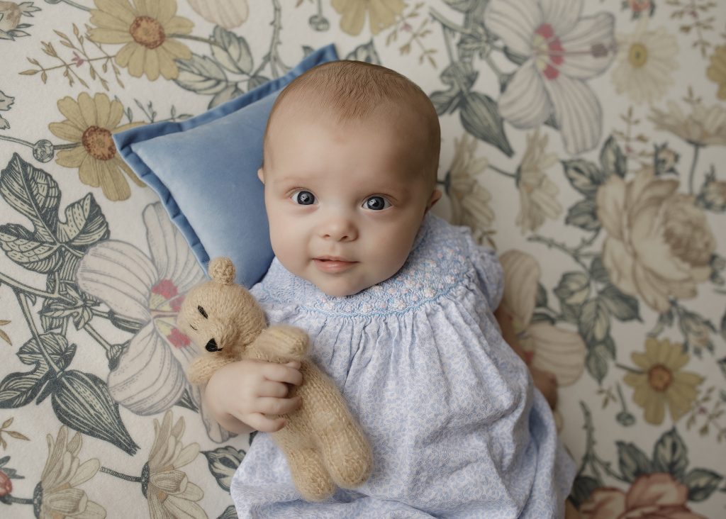 3 month old baby holding a teddy bear